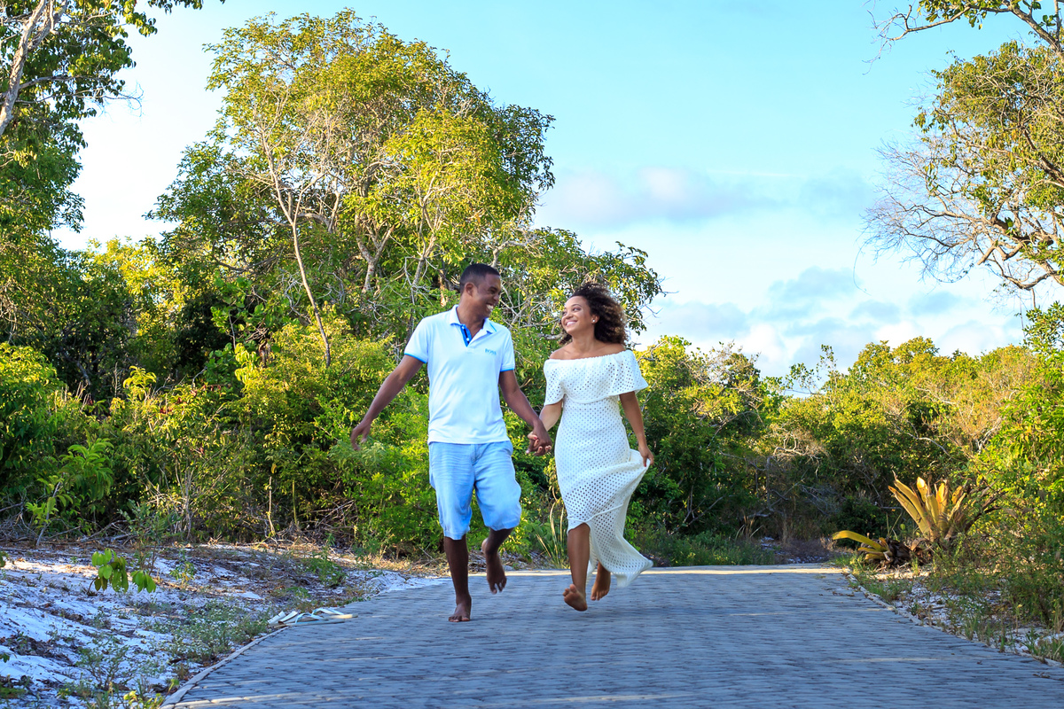 casal correndo se olhando em ensaio na praia do forte