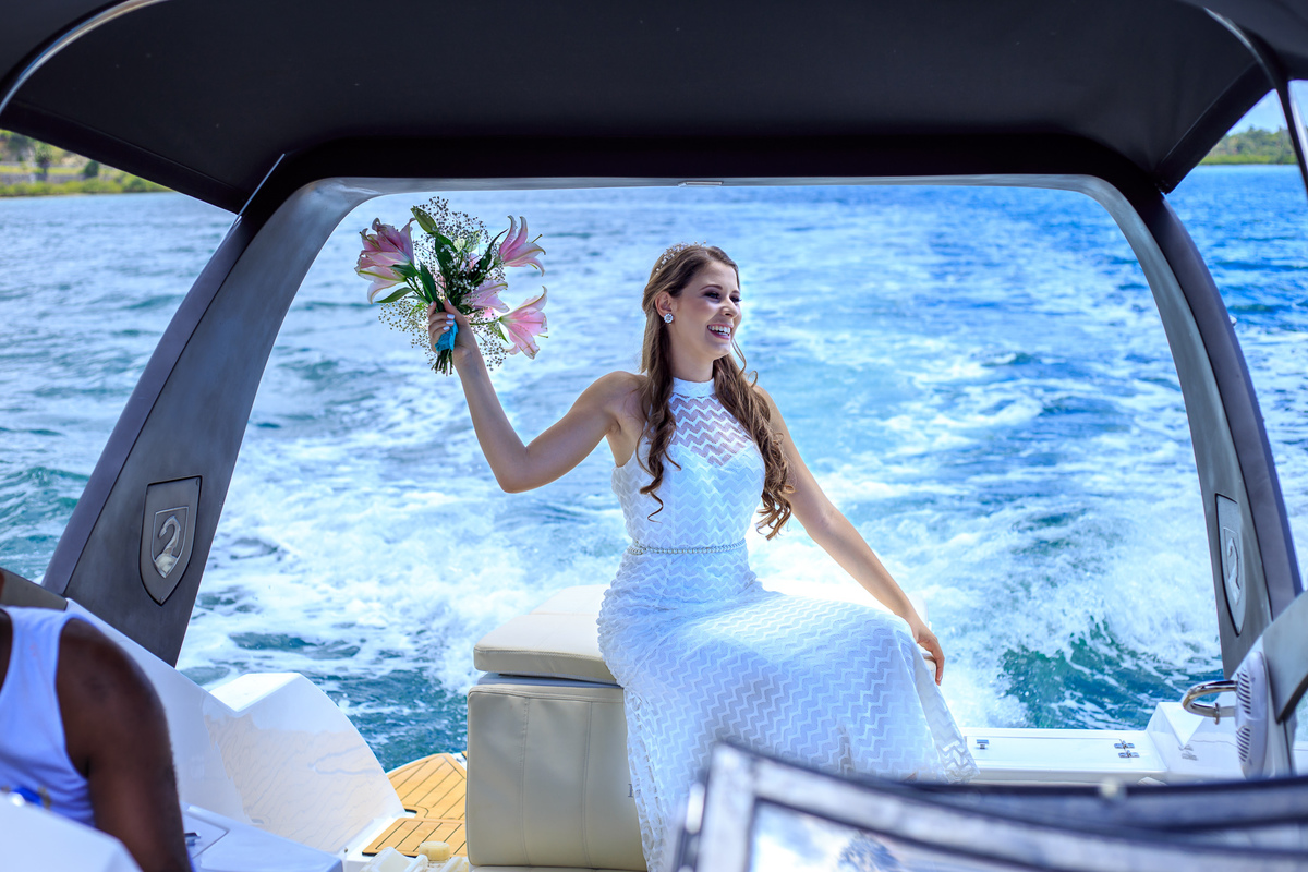 foto de noiva rindo em um passeio de lancha até o casamento de dia na praia