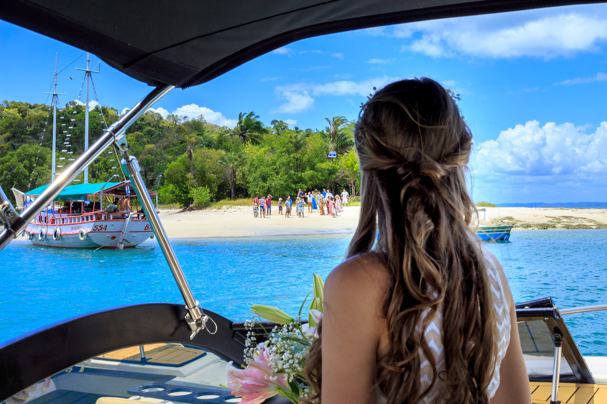 fotografia de noiva olhando para os convidados de dentro do barco