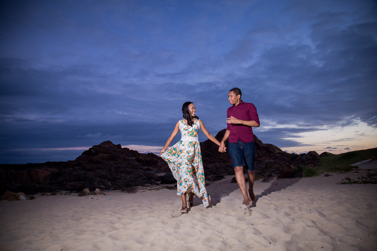 casal correndo apaixonado no farol da barra em Salvador