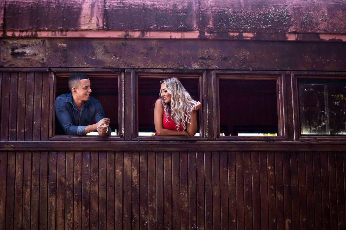 fotografia de noiva vestida de vermelho na janela do trem da praia de Guarajuba - Bahia