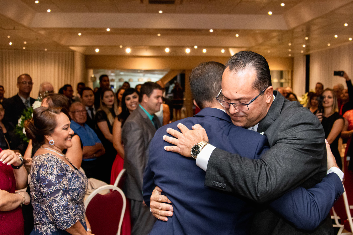 pai da noiva abraçando o noivo na entrada e=no casamento em salvador