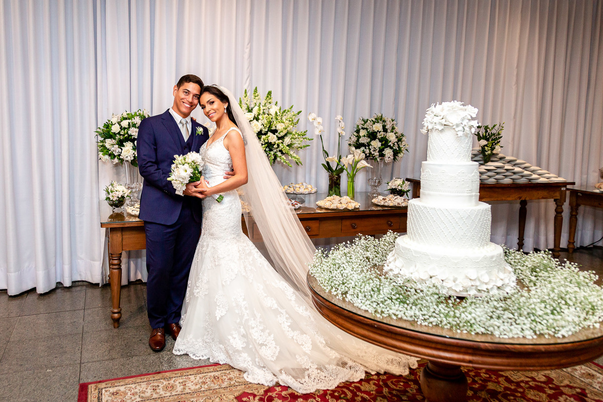 foto dos noivos na mesa do bolo branco no casamento em salvador