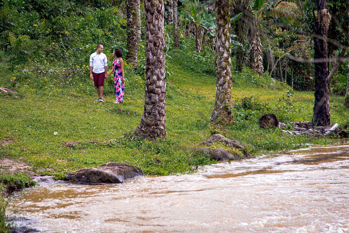 foto casal no ensaio andando em área verde perto da cachoeira