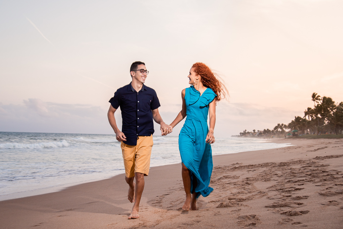 Ensaio fotográfico na praia de Vilas do Atlântico correndo de mãos dadas na praia