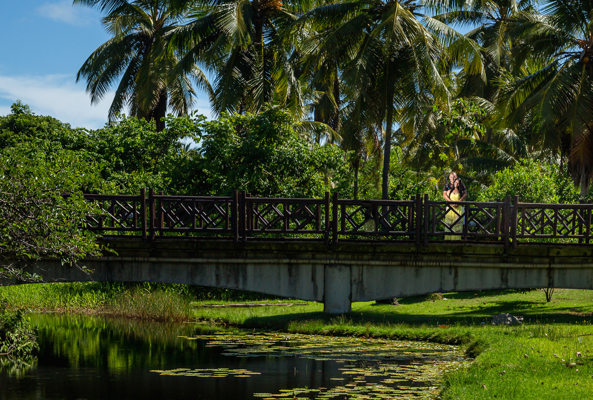 Fotografia de casal de noivos (pré-casamento) no Resort Costa do Sauipe em ambiente verde com lago 