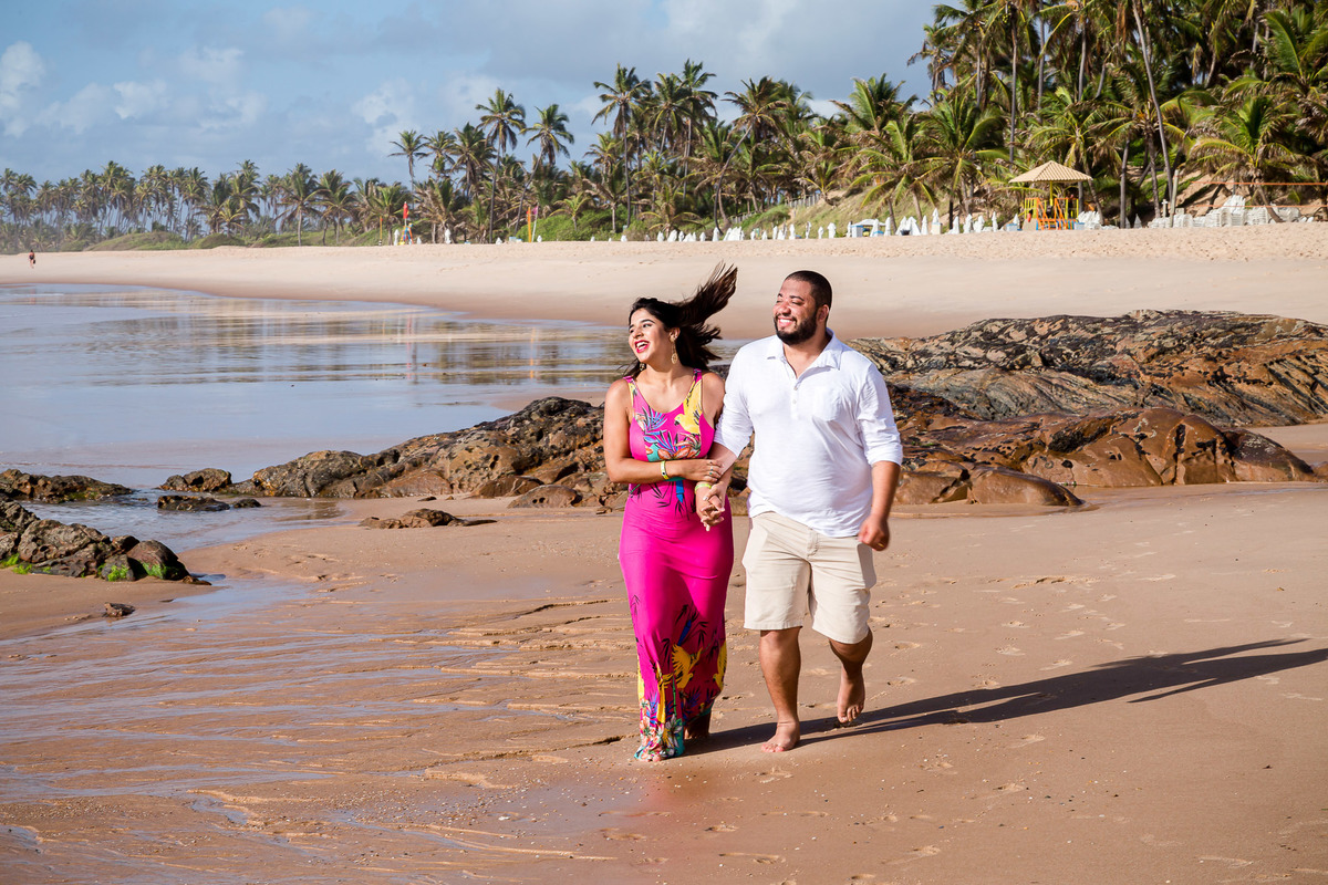 Fotografia casal correndo na praia do resort costa do saiupe em um ensaio fotográfico romântico