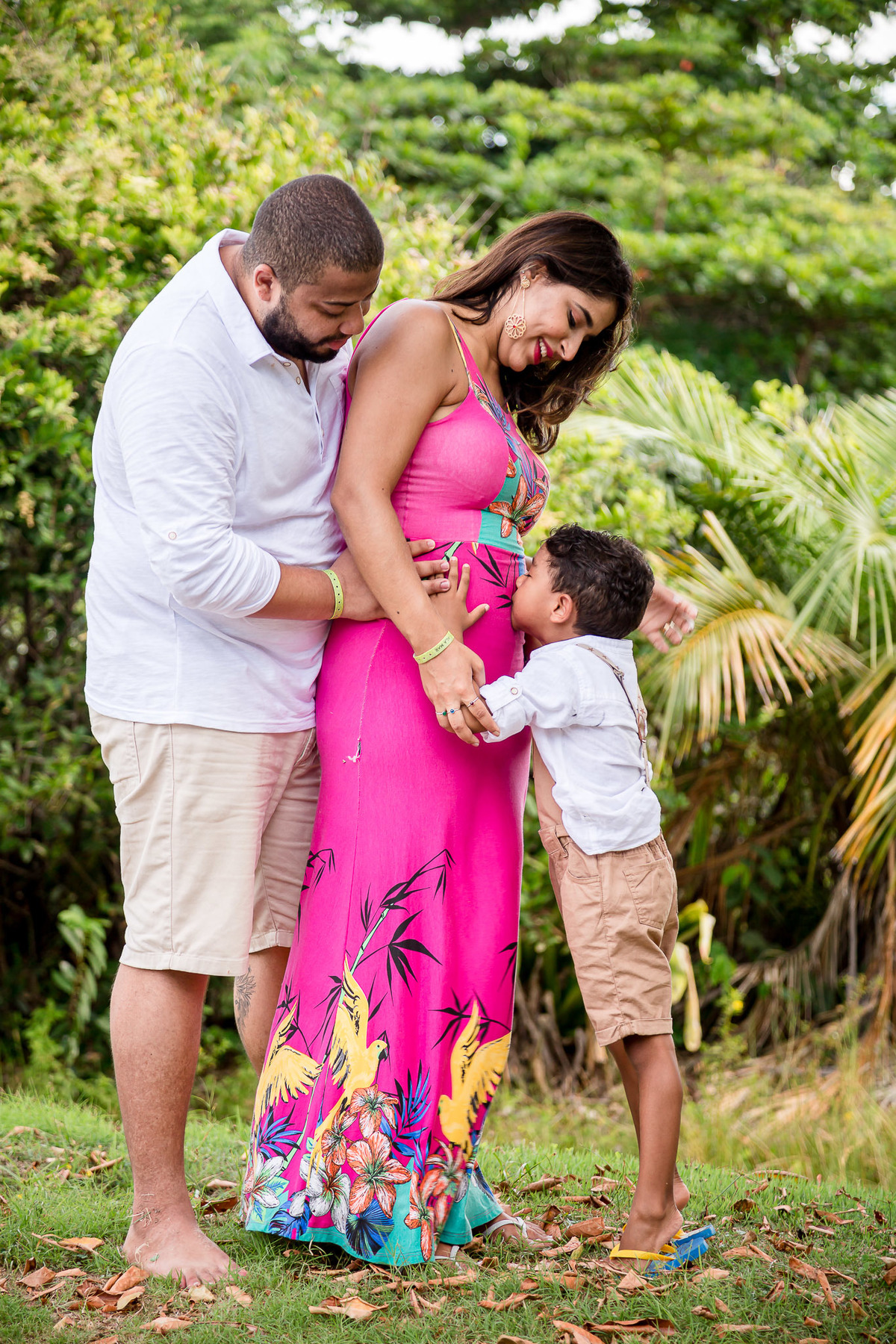 Filho beijando a barriga da mãe gestante em ensaio fotográfico no resort da costa do sauipe