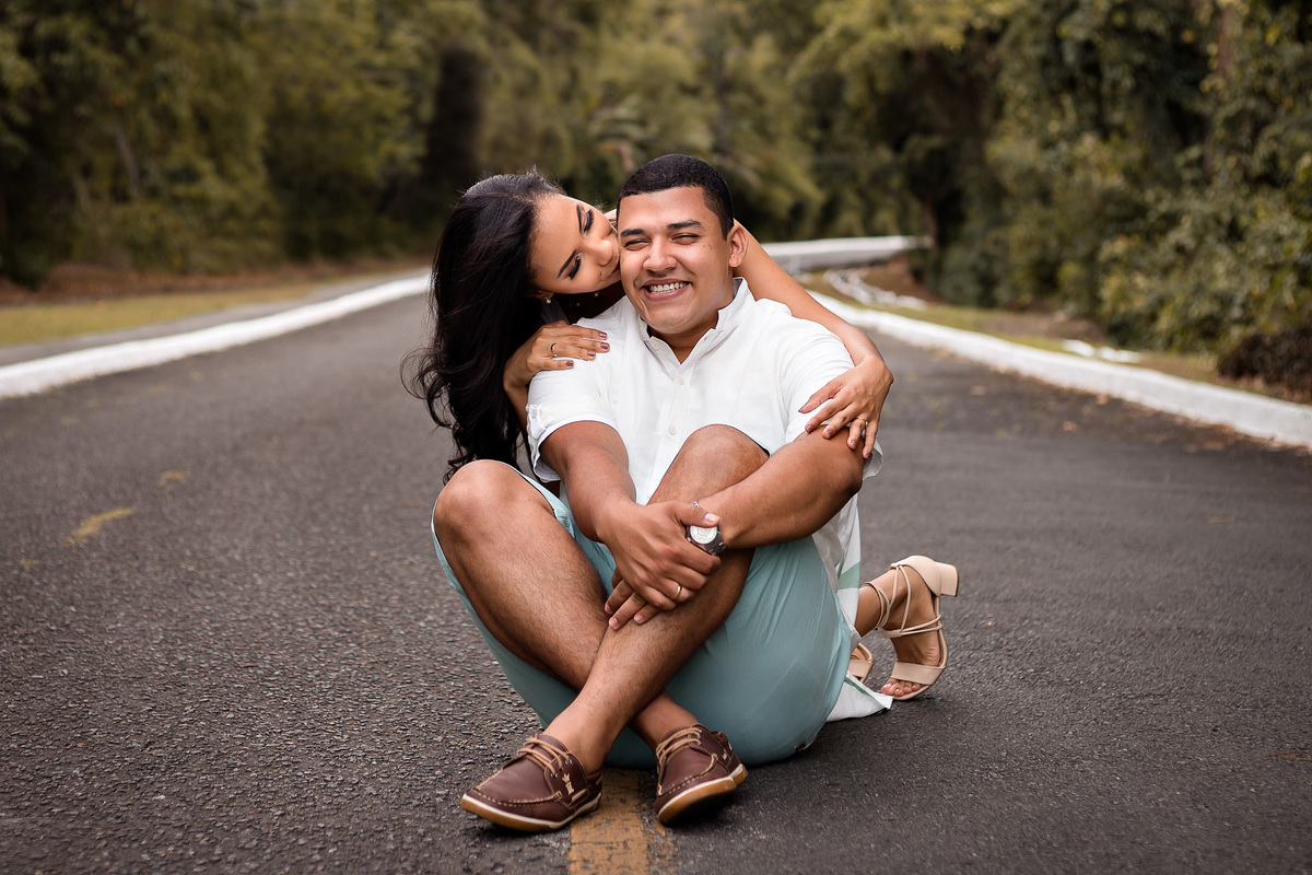 Fotografia de casal no meio da pista sorridentes