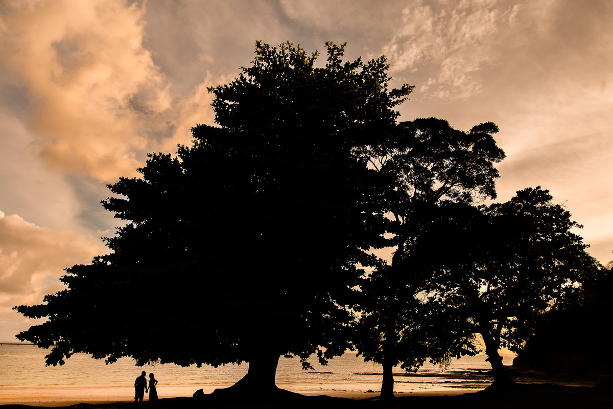 Casal em silhueta na praia de Inema ao por do sol