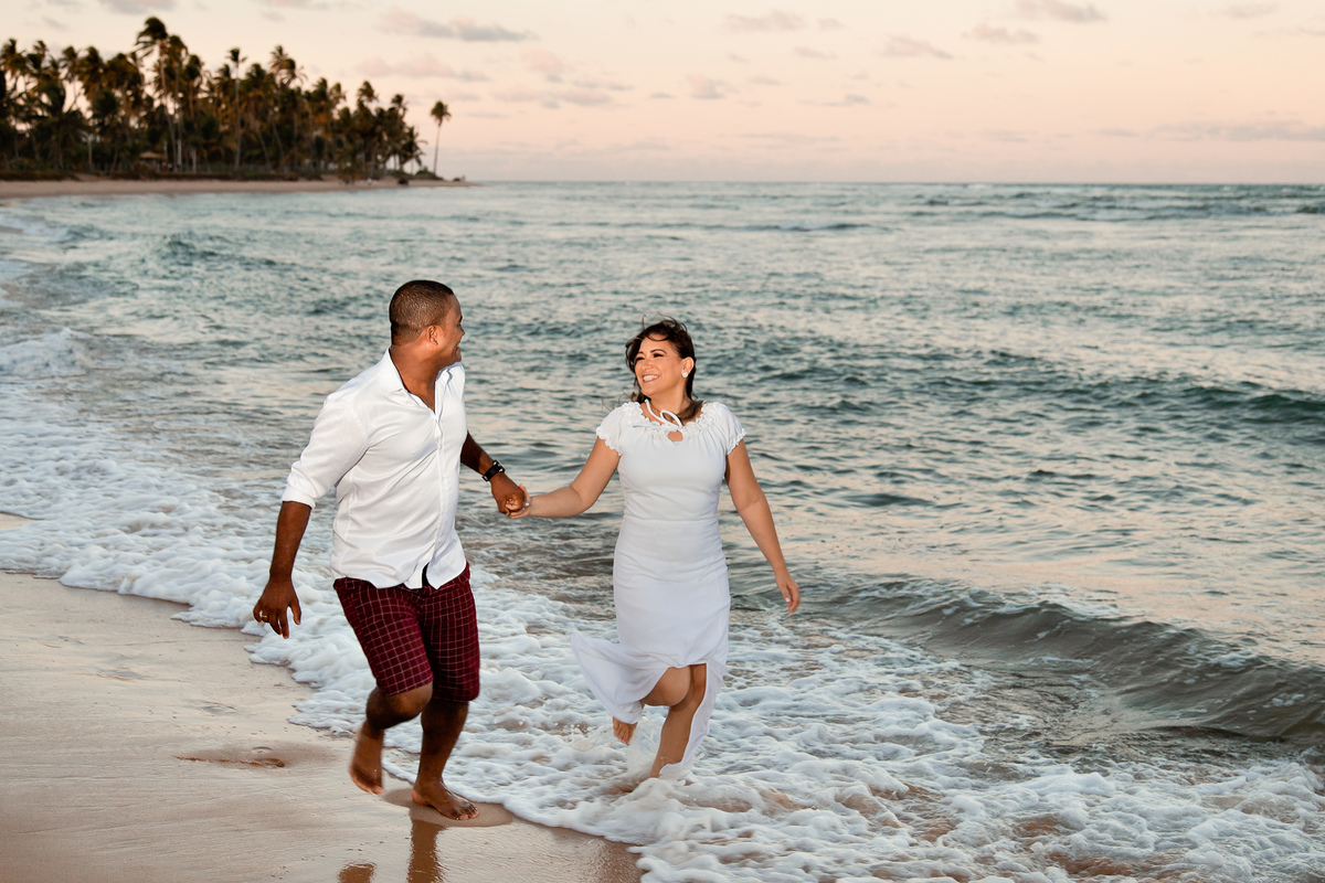 ensaio fotográfico casal correndo na praia do forte bahia