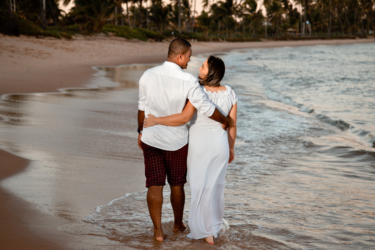 ensaio fotográfico noivos andando na praia do forte bahia
