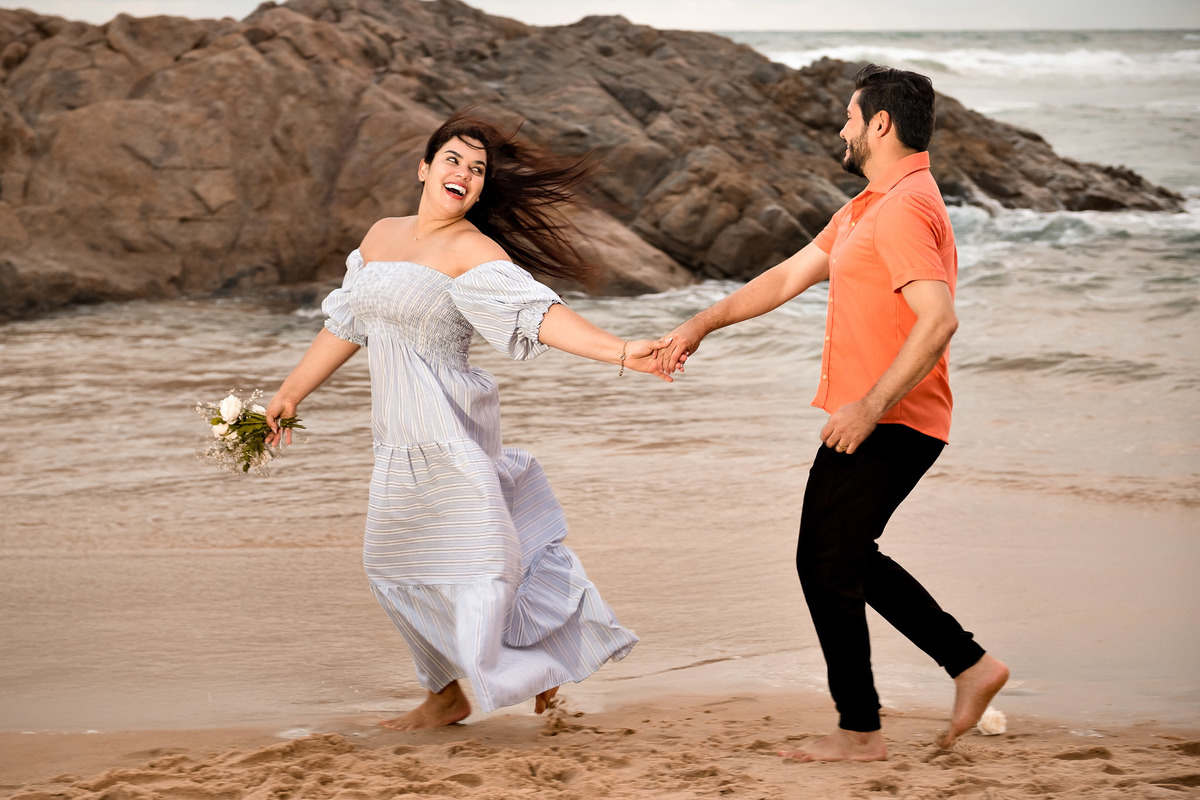 casal se divertindo correndo na praia fazendo ensaio de bodas na Bahia