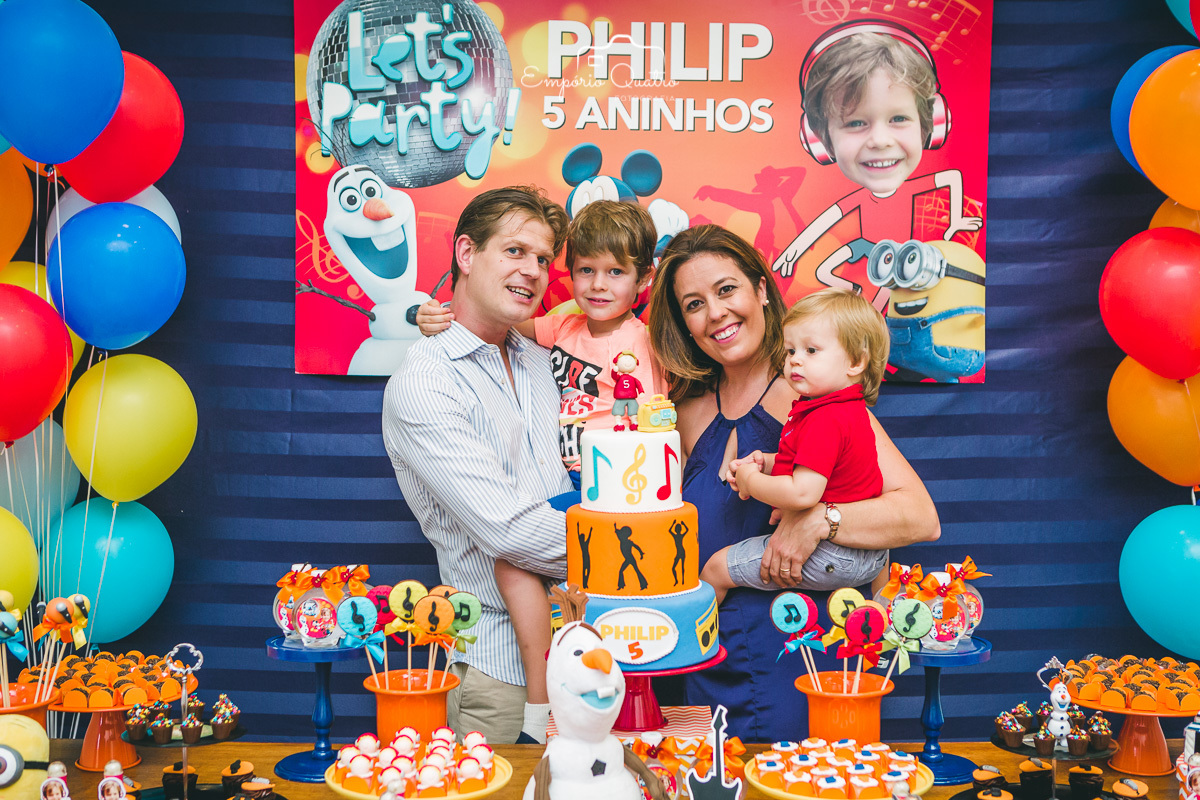 fotografia aniversário aniversariante ao lado da família na mesa do bolo decorada no tema dj