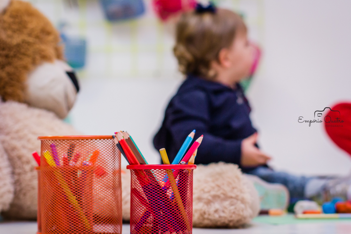 fotografia aniversário convidada desfocada ao fundo com caixas de lápis a frente