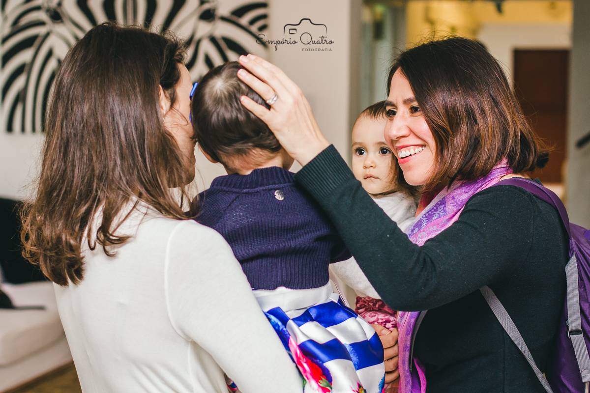 fotografia aniversário aniversariante brincando com convidada no colo da mãe