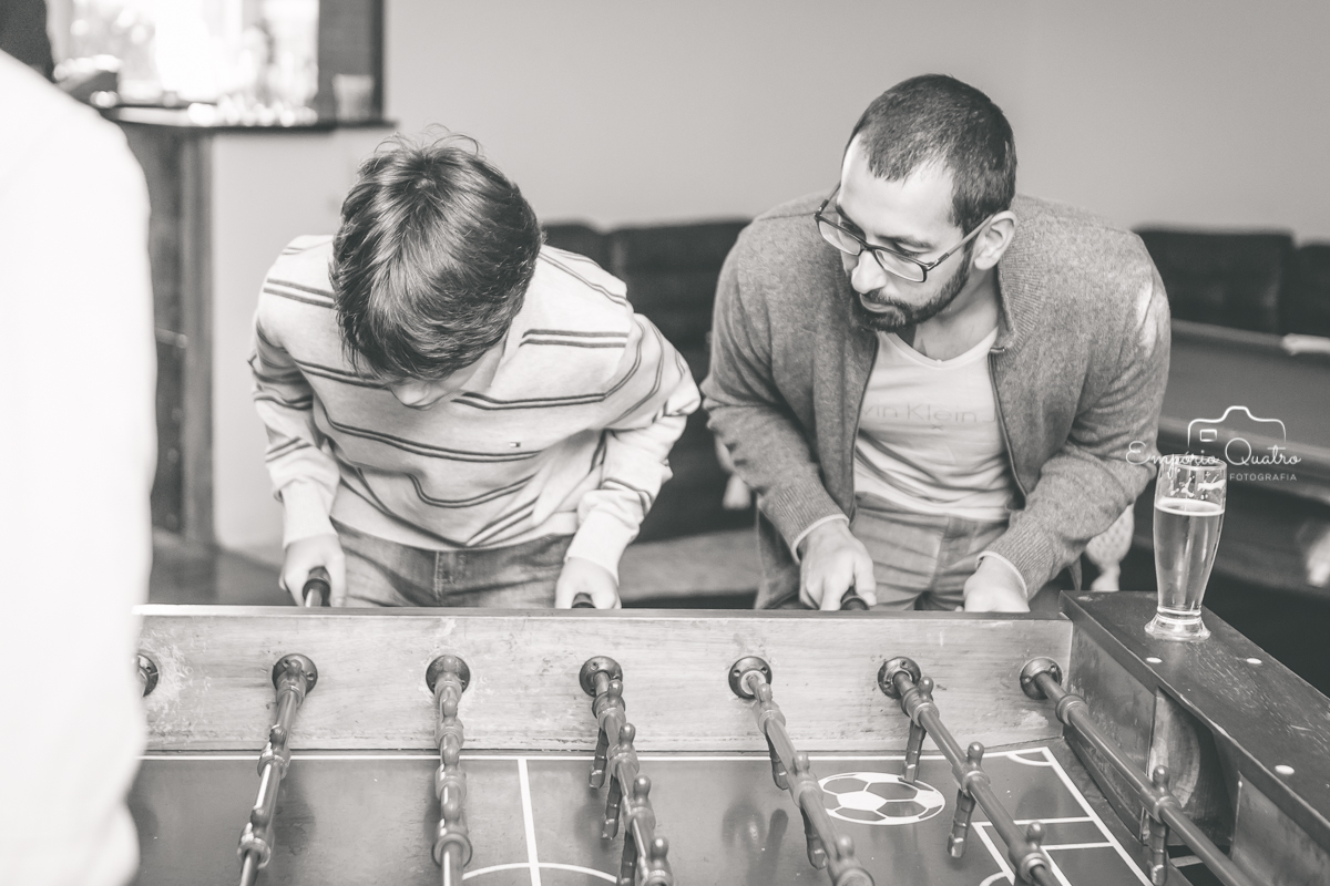 Convidados jogando pebolim em preto e branco
