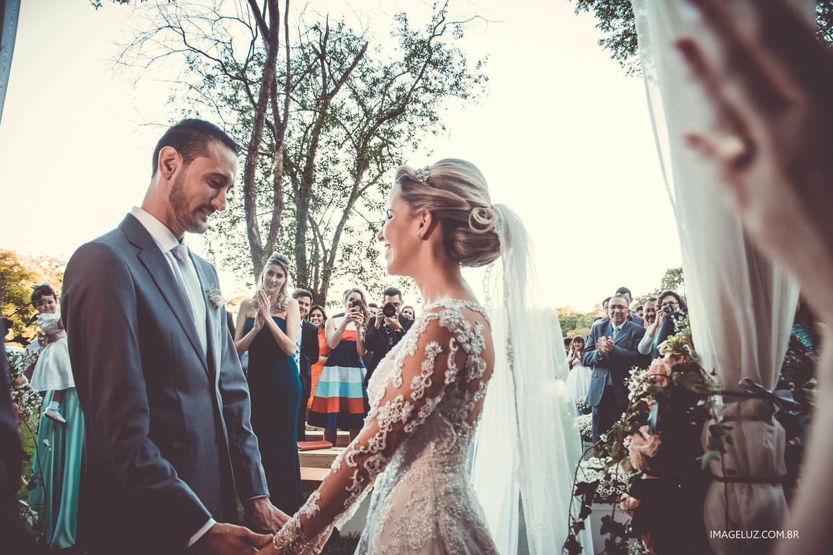 Enfim casados, noivos de mãos dadas em frente ao altar.
