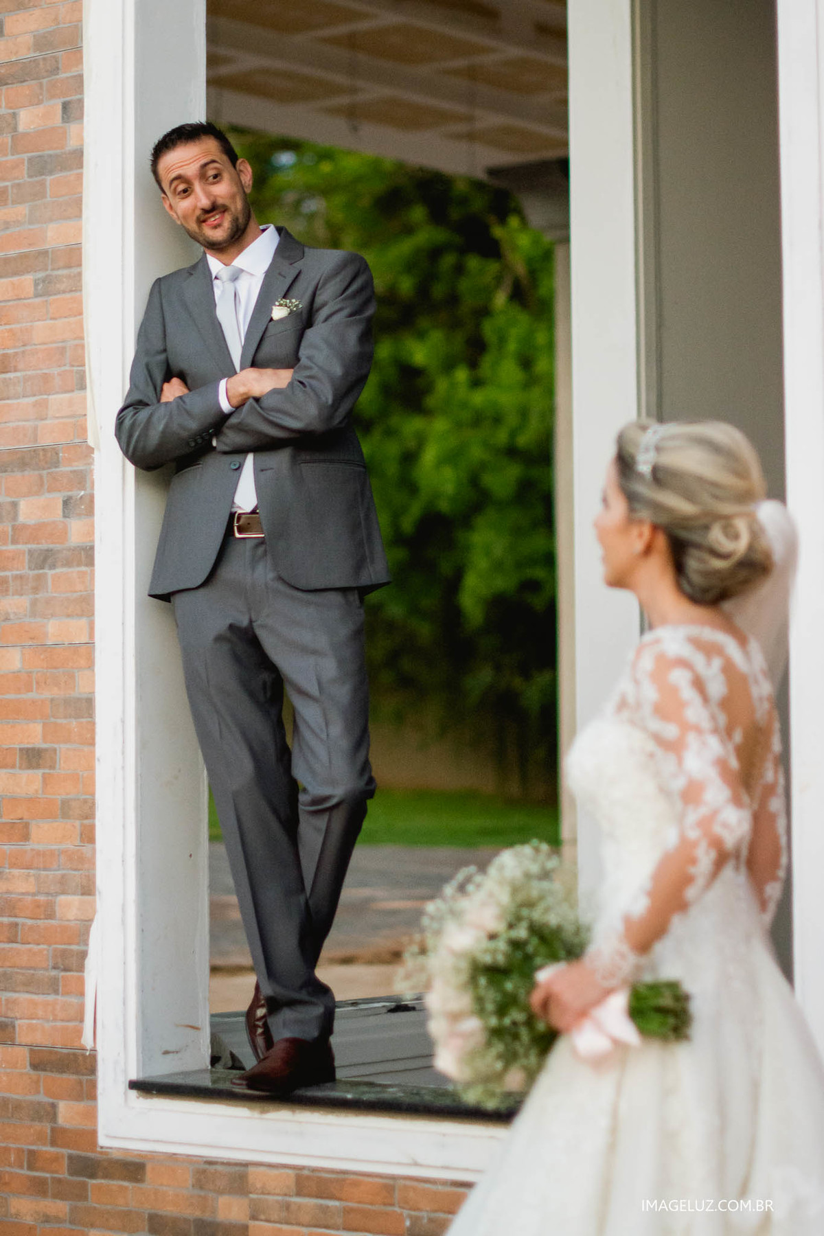 Noivo emoldurado por uma janela, em uma linda tarde de sol.