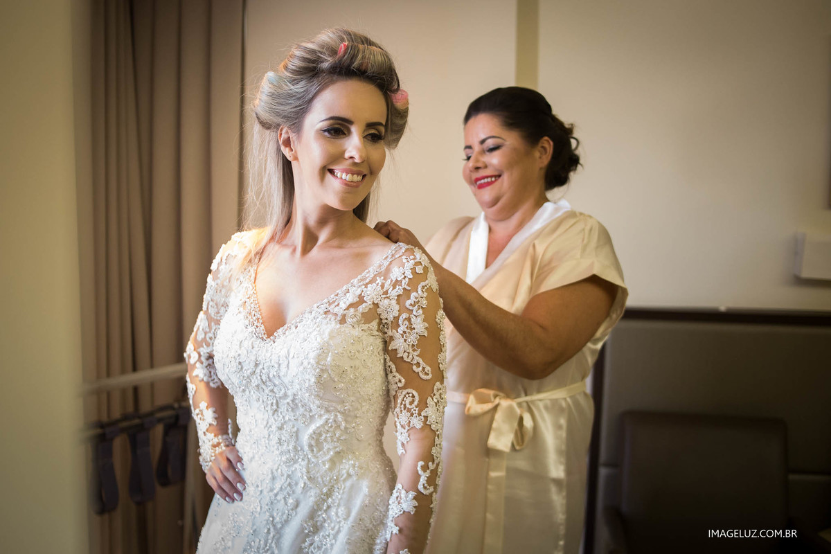 A mãe da noiva fechando o vestido é um detalhe que não pode faltar.