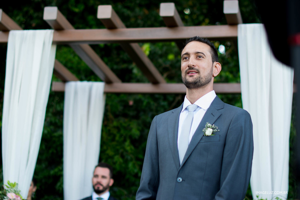 O noivo sorridente esperando sua amada no altar.