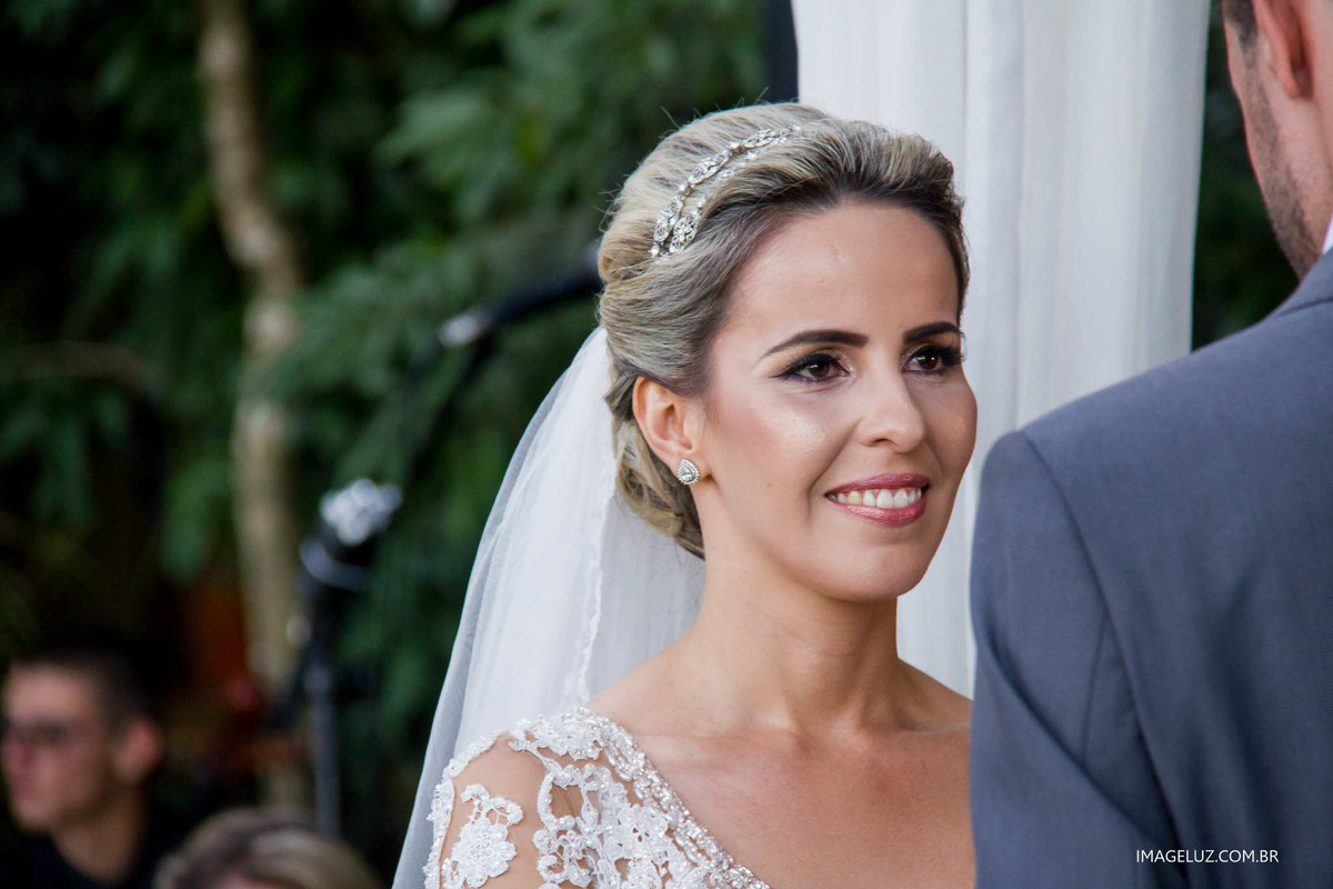 Noiva sorri ao ver seu noivo lendo os votos do casamento 