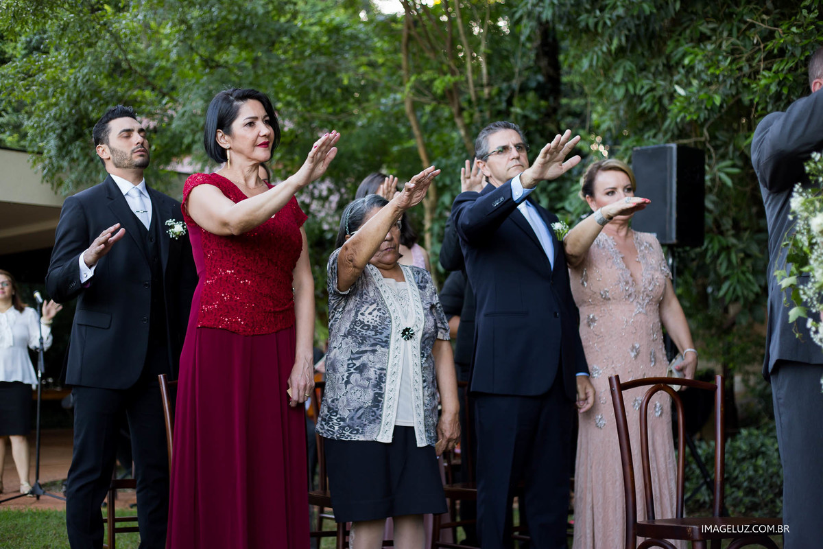 Padrinhos orando pelos noivos em casamento.