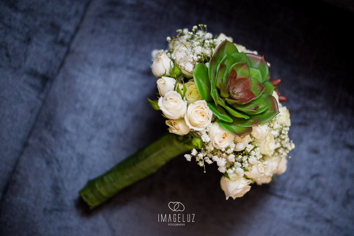 Buque da noiva lindo contrastando com a cor do sofé.