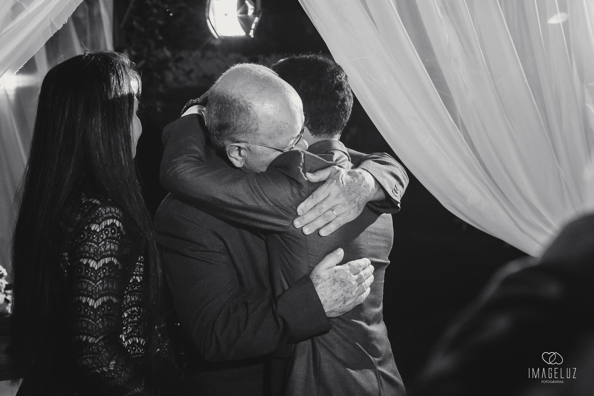 noivo abraçando seu pai no altar.