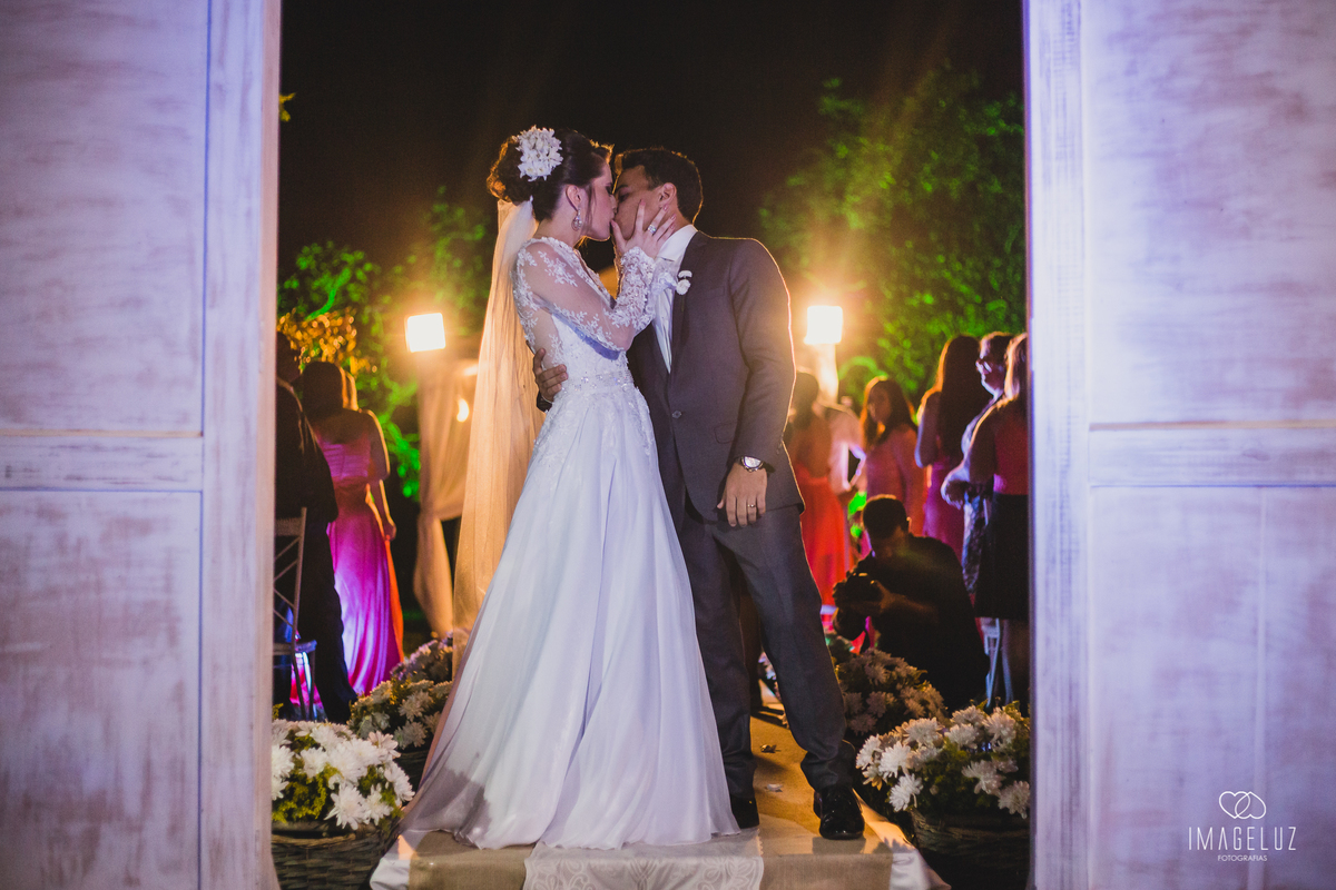 noivos dando o beijo na saida do casamento