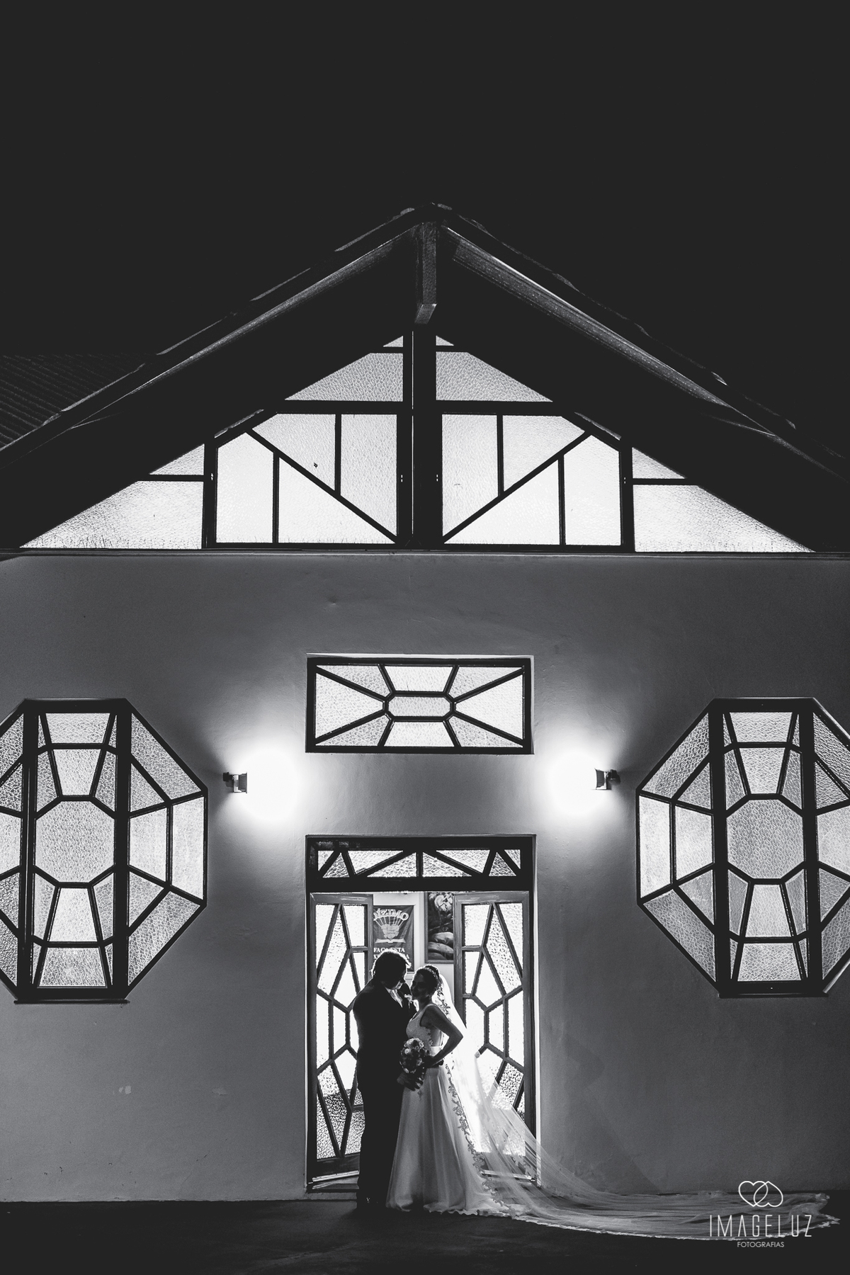 Noivos em uma silhueta na porta da igreja.