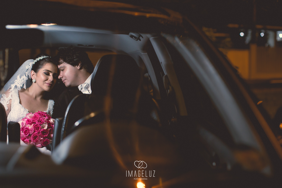 Noivos dentro carro a caminho da festa.