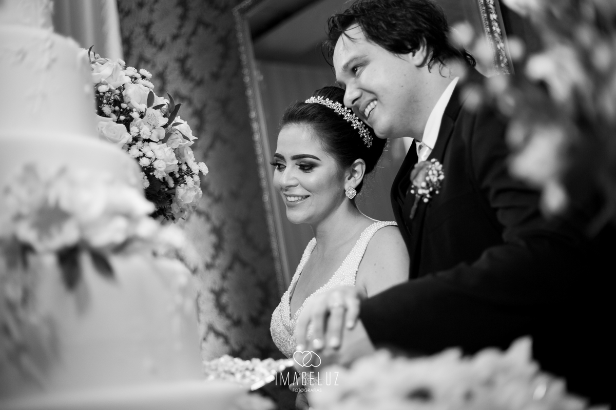 Noivos cortando o bolo.