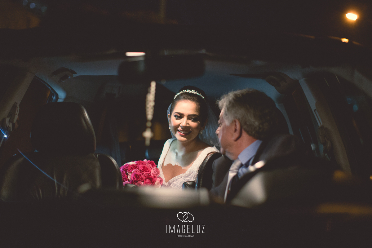 Noiva chegando de carro na igreja, com seu pai ao volante. 