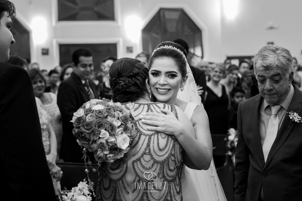 Noiva abraçando a mãe do noivo, muito emocionada.