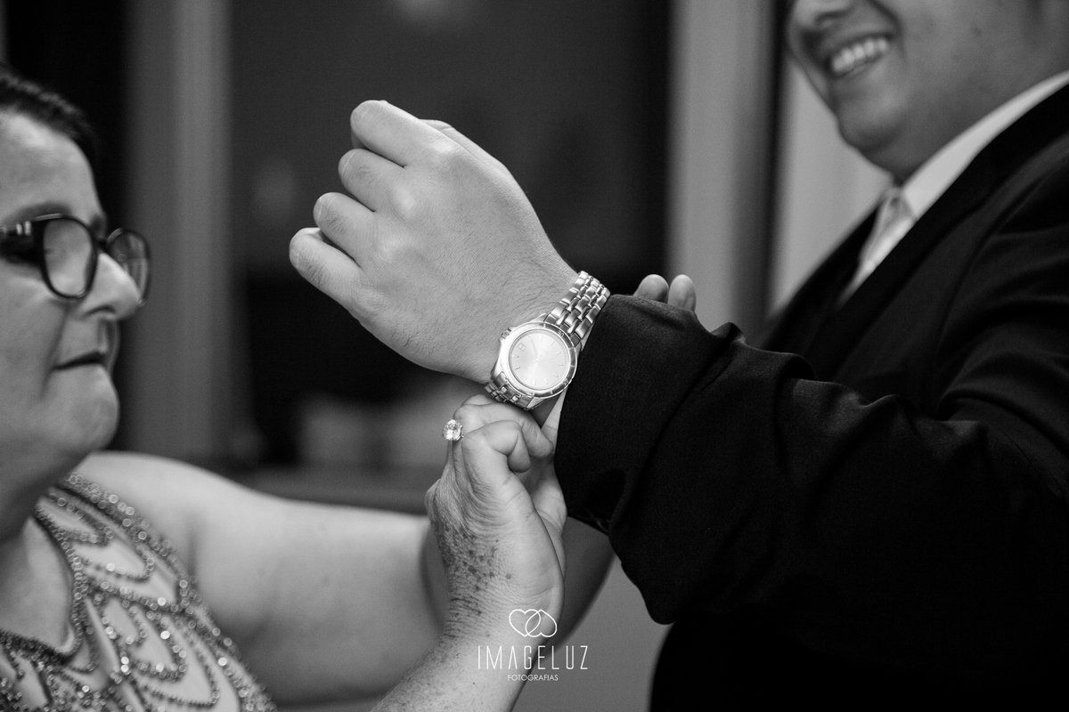 Mãe do noivo ajudando ele a se vestir para seu casamento em cuiabá. 