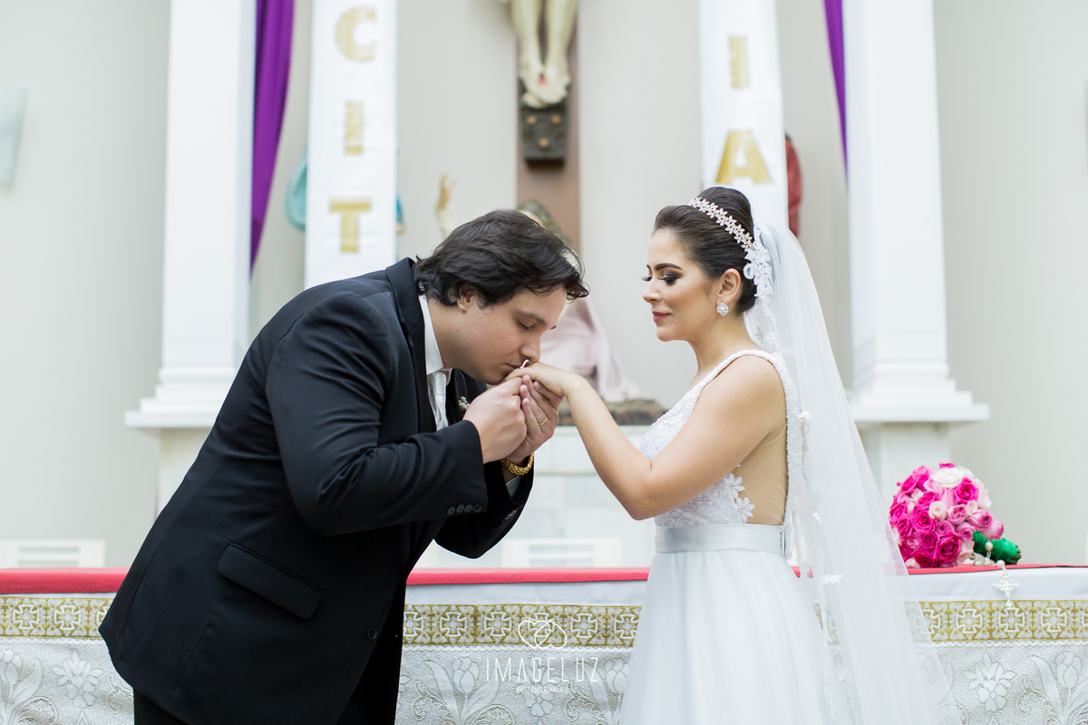 Noivo beijando a mão da noiva após colocar a aliança.