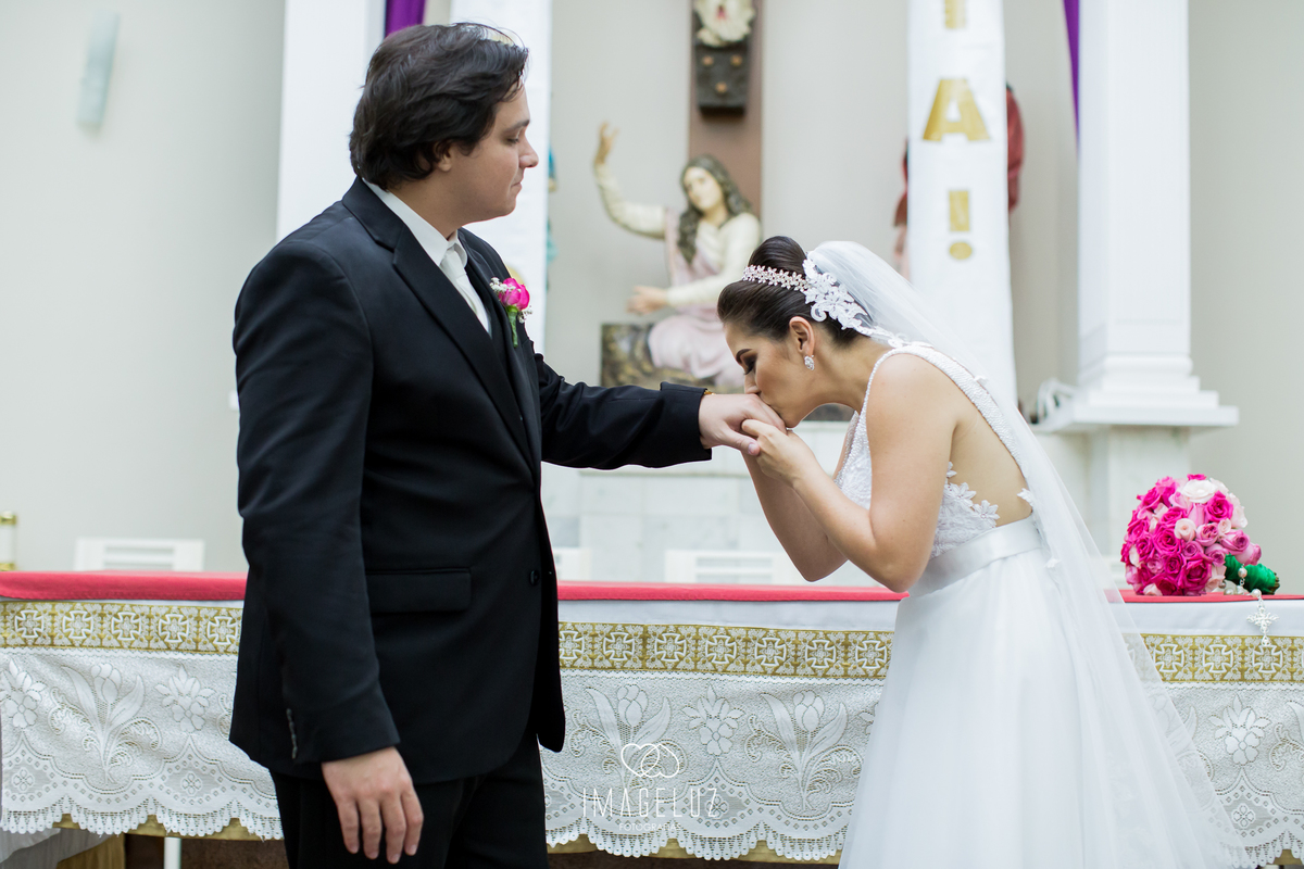 Noiva beijando a mão da aliança de seu noivo.