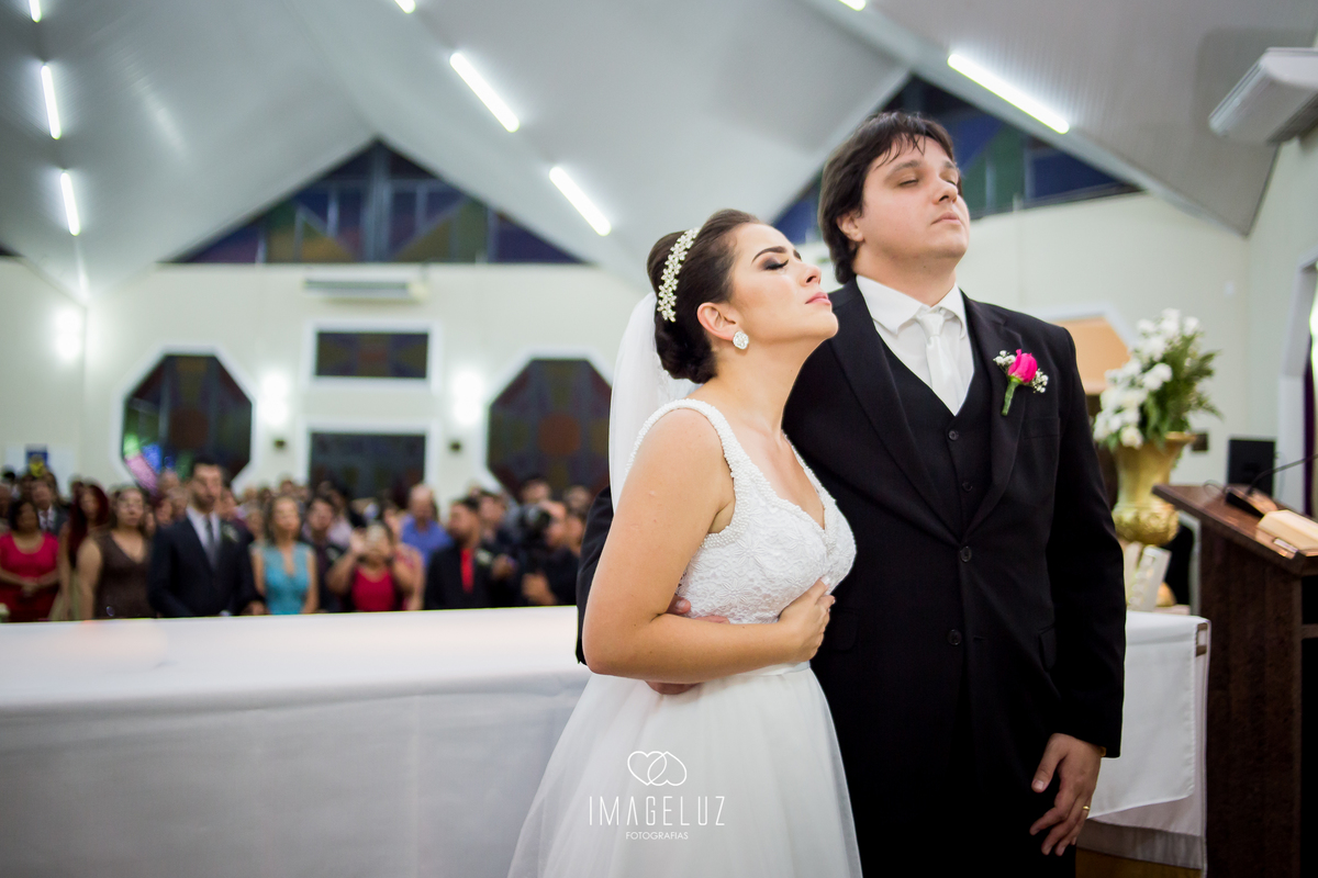 Noivos rezando no altar.