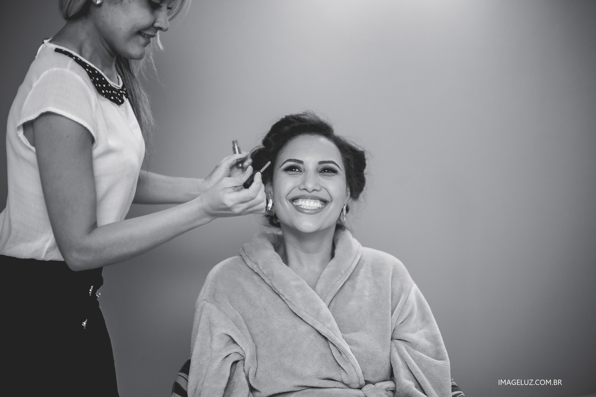 noiva sorrindo ao ser maquiada. Fotografia-de-casamento-em-Cuiabá