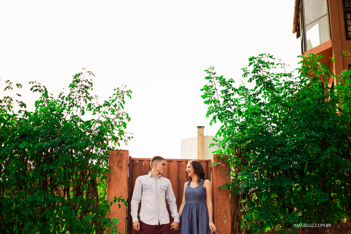 casal parado em frente a um portão no morro dos ventos