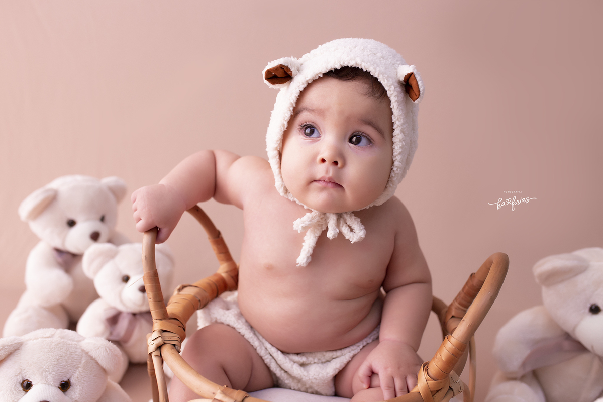 o menino esta vestido de ursinho para a sessão em estudio