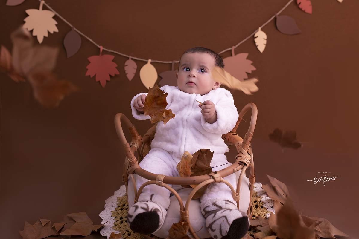 a bebe brinca coma s folhas no cenario de outono