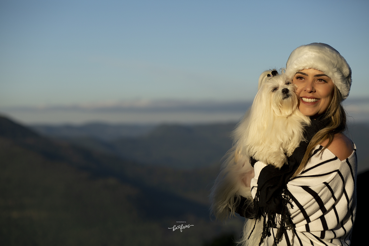 a modelo abraça a cachorrinha no ensaio externo