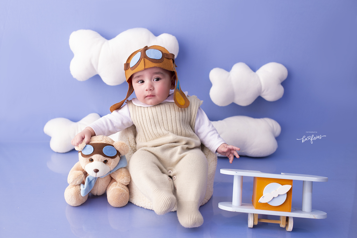 o menino esta vestido de aviador para as fotos mensais