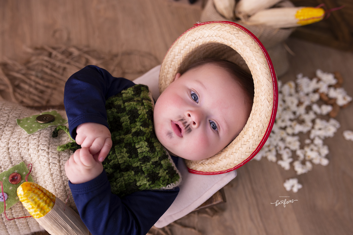 o menino esta deitado para as fotos do acompanhamento mensal