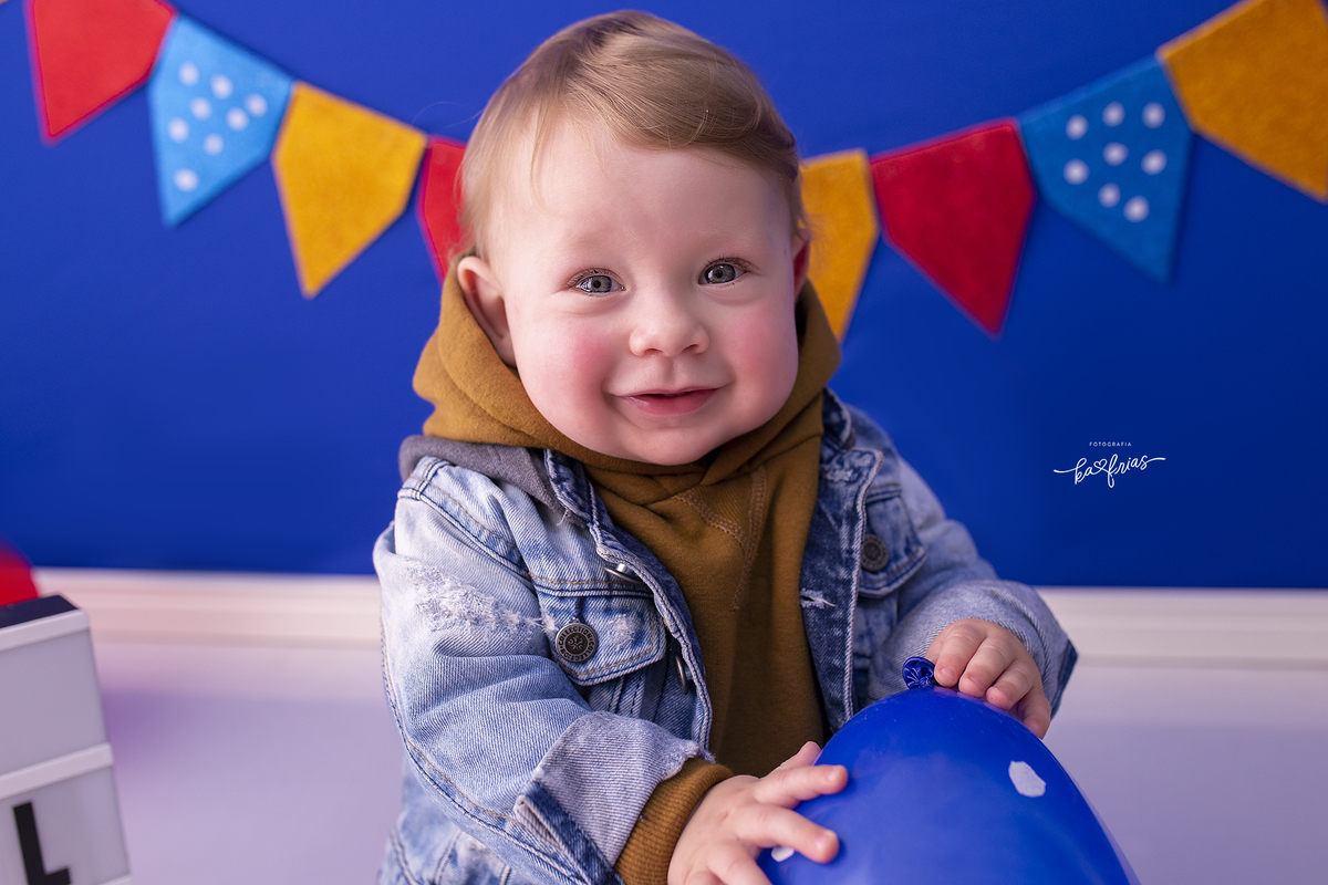 o menino brinca com o balão na sessão de fotos