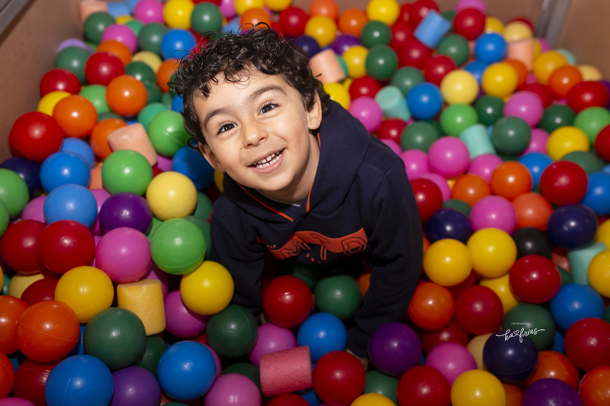 o menino brinca na piscina de bolinhas