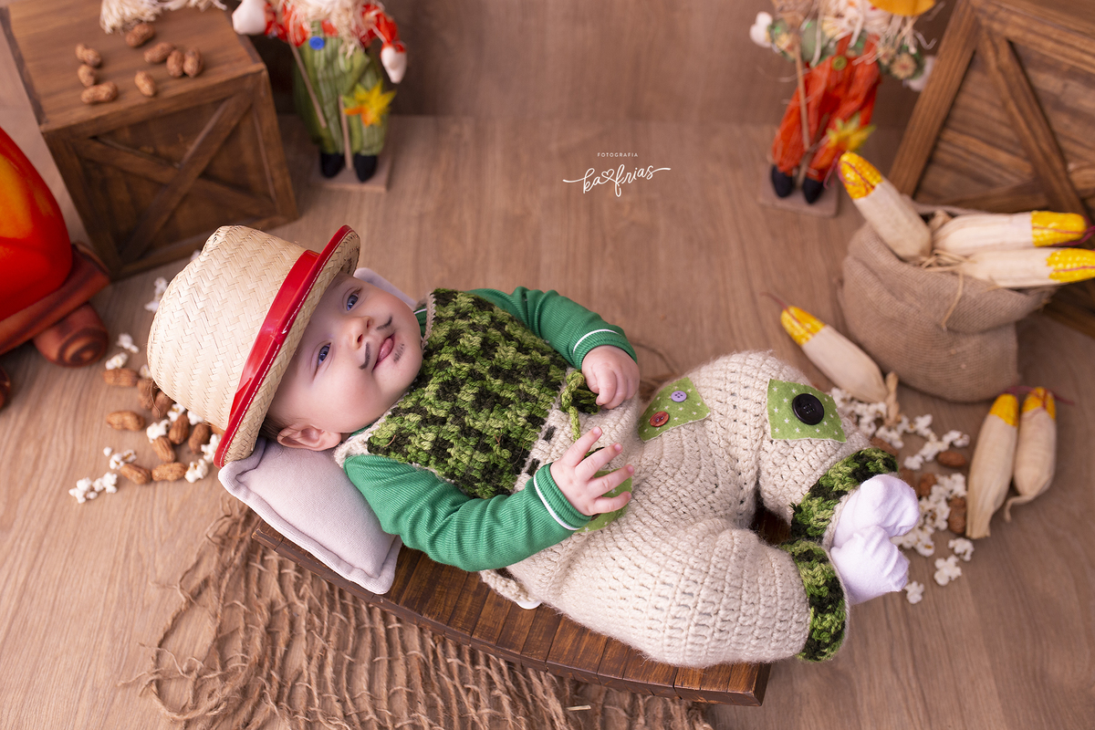 o menino esta vestido de caipira para as fotos mensais