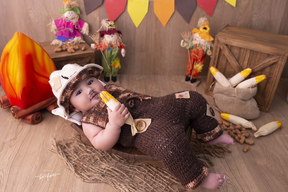 o menino esta vestido de caipira para as fotos mensais